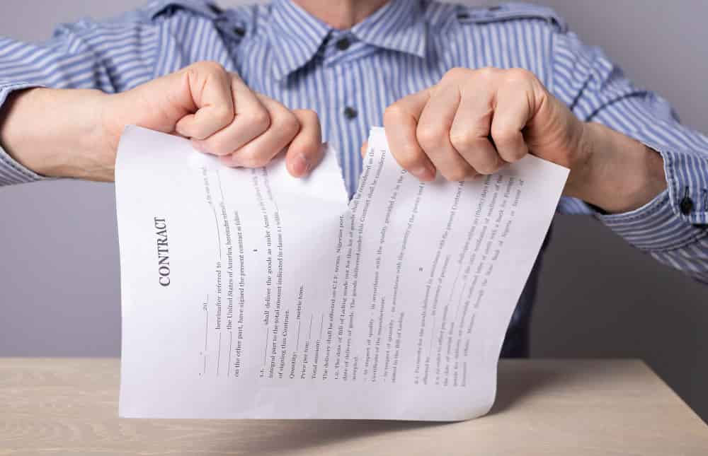 A man tearing a page indicating Joint venture termination agreement
