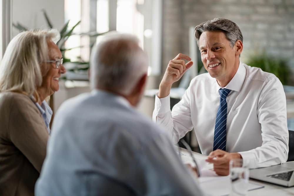 happy insurance agent talking with mature couple about their retirement plans during meeting office min - Sue Someone in Commercial and Business Law