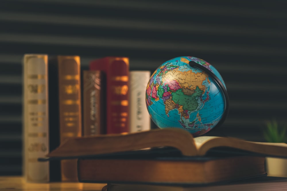 A globe and law books symbolizing sue someone for legal disputes abroad