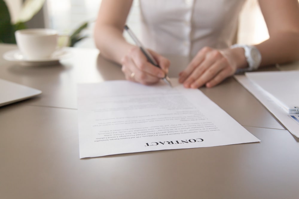 A women signing a contract after doing contract interpretation