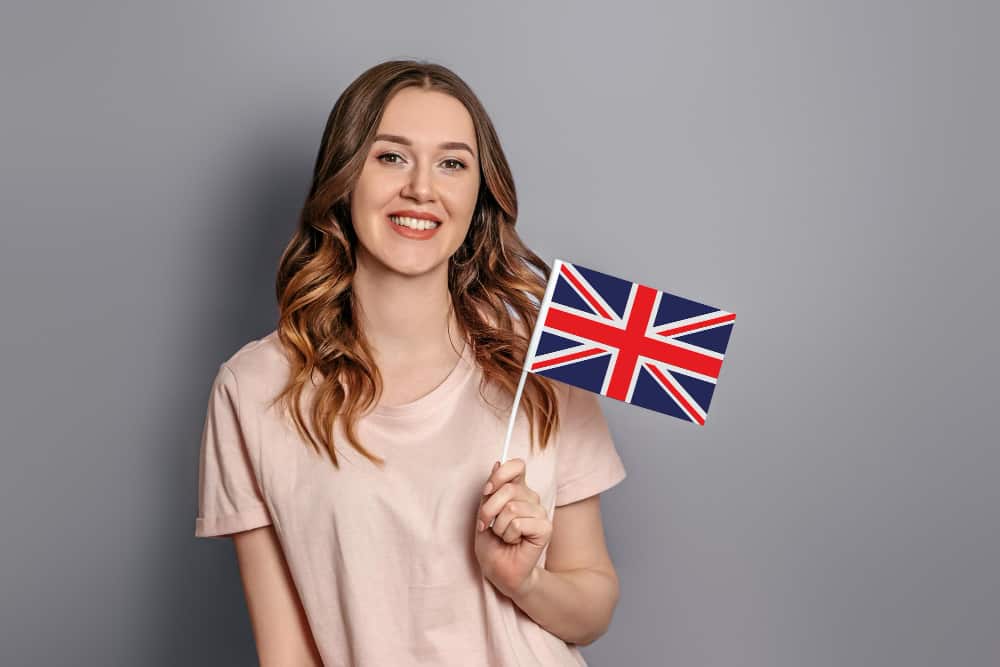 A women holding a UK flag ready to immigrate from the US to UK
