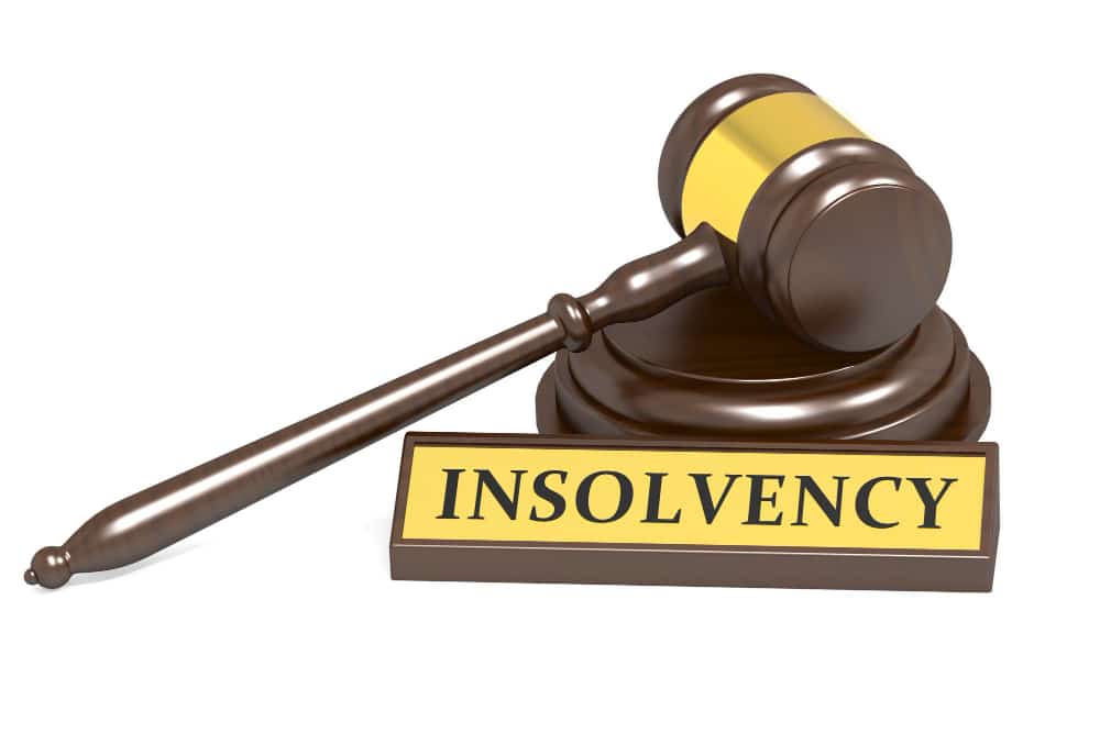 A wooden hammer and its stand with a board of insolvency