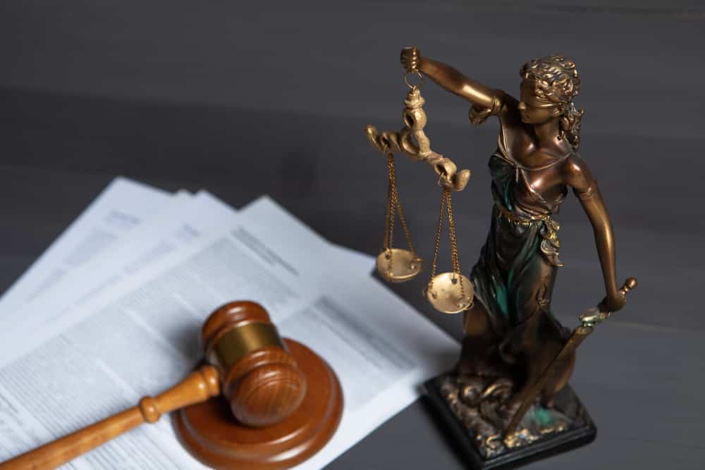 A lady of justice along with wooden hammer and papers on Director Liabilities