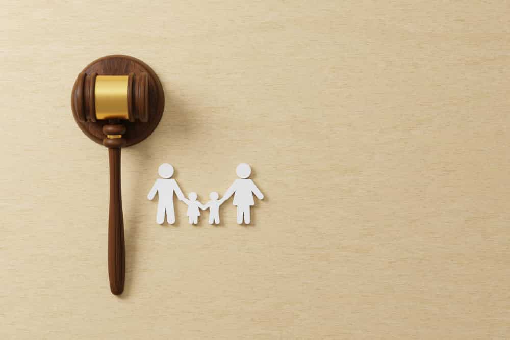 A wooden hammer with a family picture symbolizing custody and divorce on international scale

