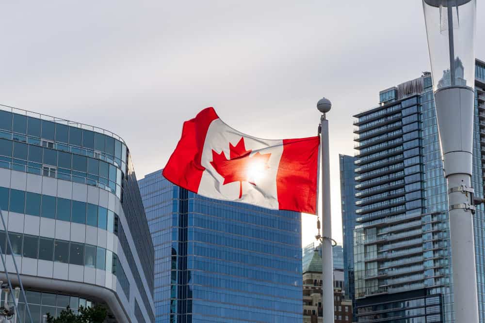 close up national flag canada vancouver city skyscrapers skyline background min - Brazilian obtain a visa for Canada in Immigration Law