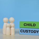 A family model with a poster on Child Custody Law in Italy