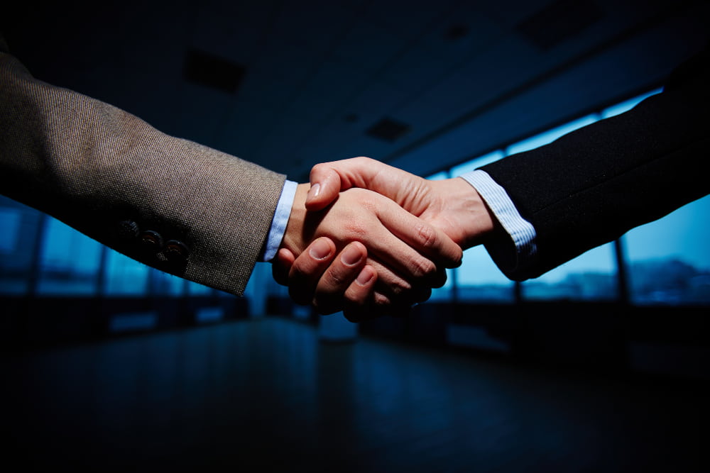 Two legamart lawyers shaking hand after resolving disputes related to joint ventures