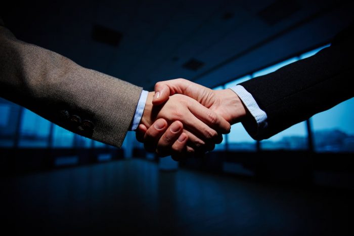 Two legamart lawyers shaking hand after resolving disputes related to joint ventures