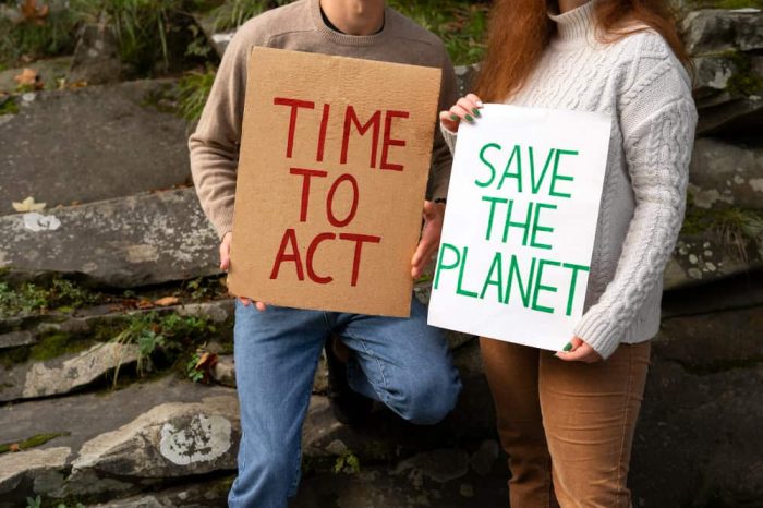 Two people holding cardboards in a rally creating awareness on environmental law in the United States